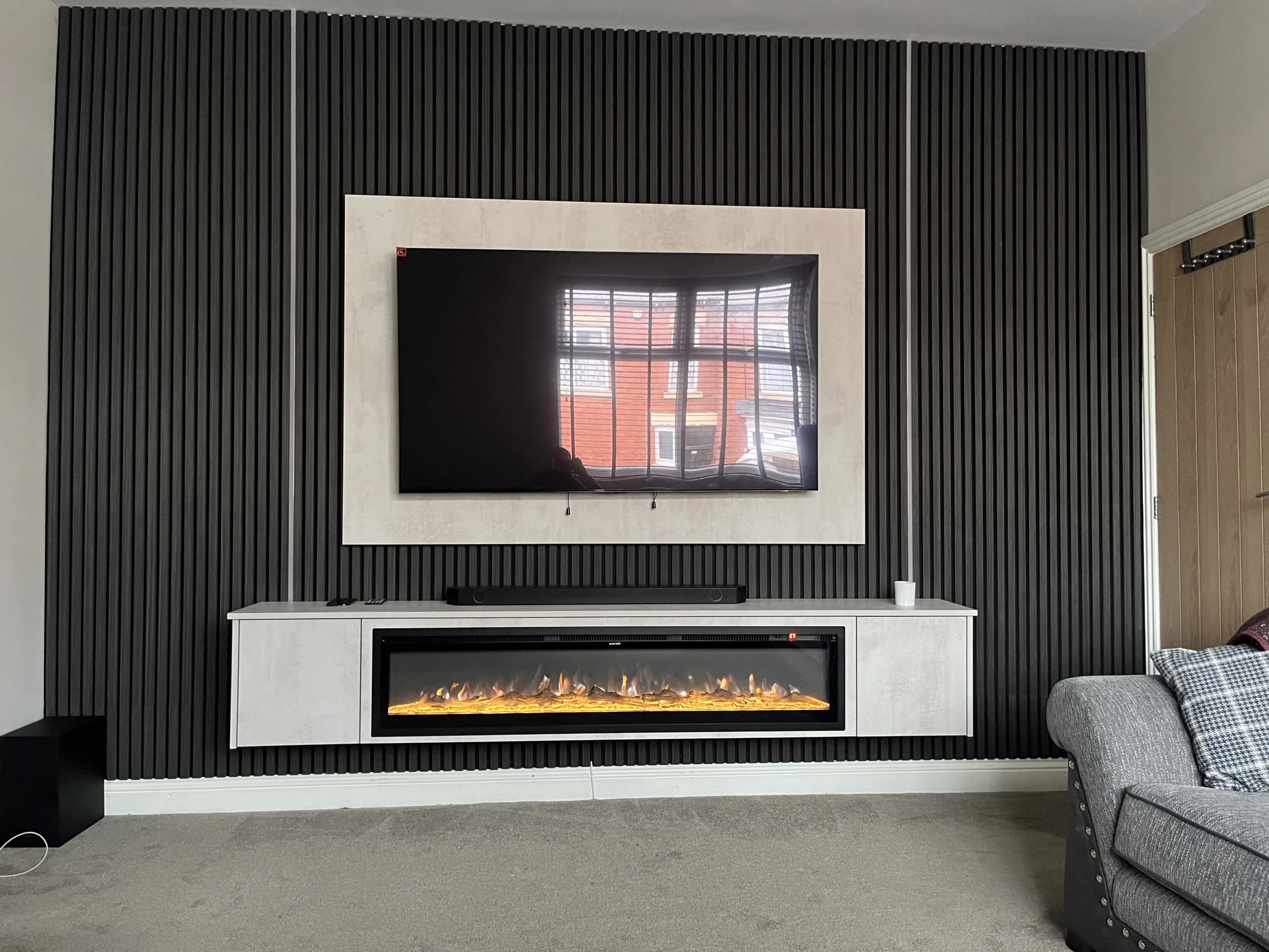 Custom media wall with electric fireplace framing and hidden cable management